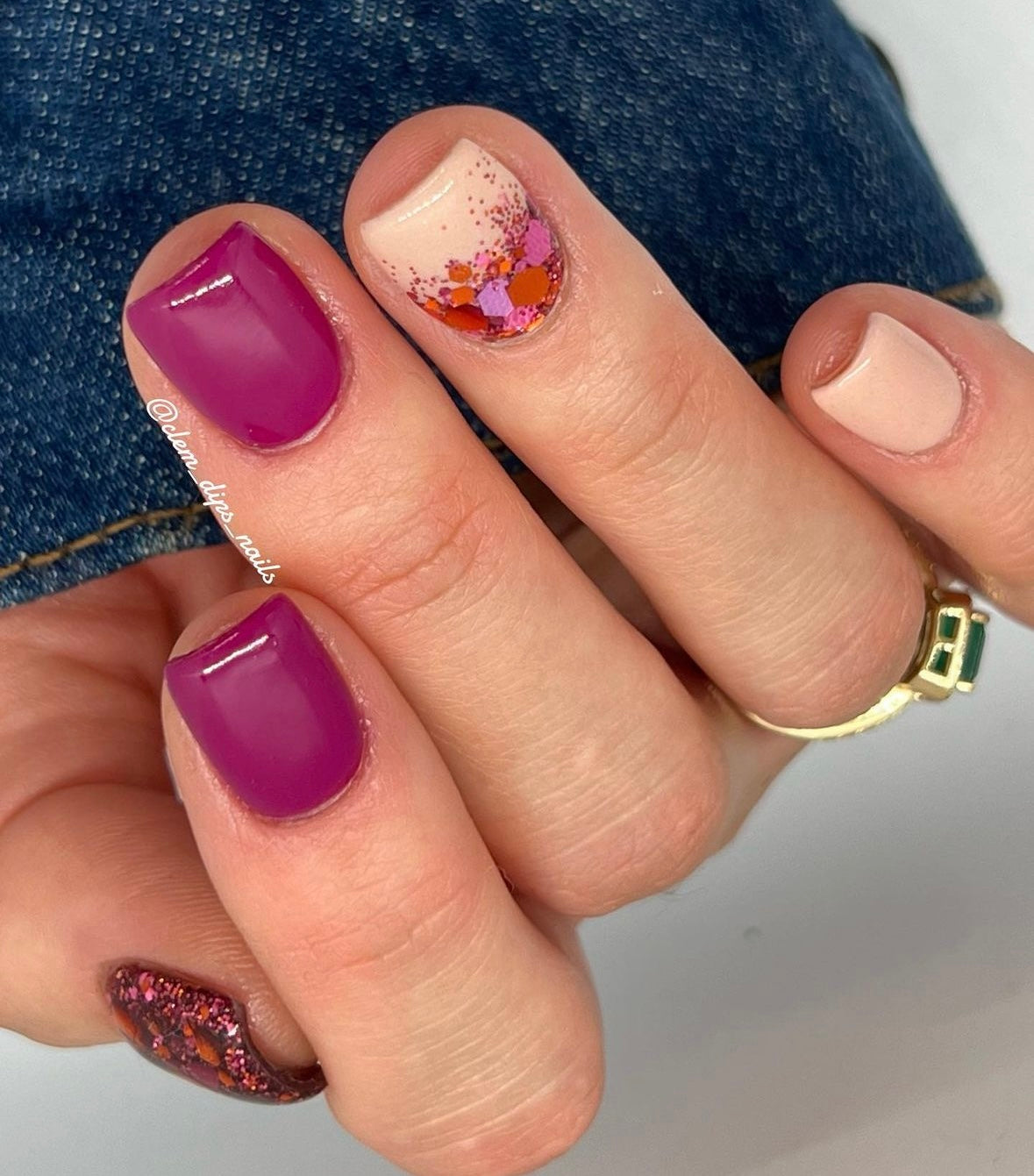 Manicure with glossy plum, nude, and pink nails, one featuring multicolor confetti glitter accents.
