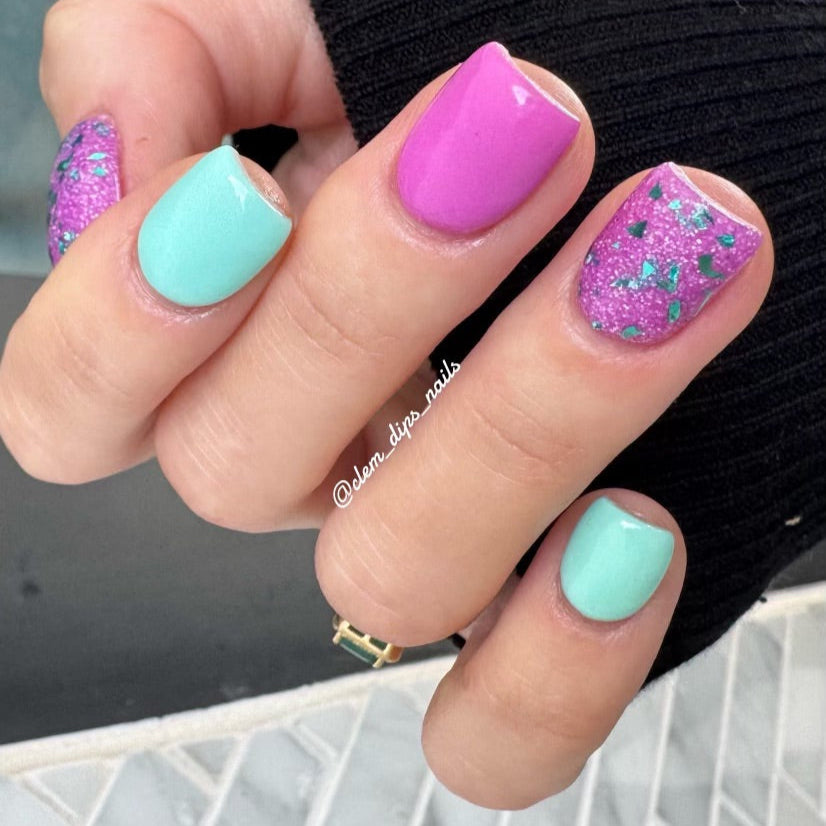 Nail art featuring DP341 Lilac Haze Glitter Dip Powder with pink and teal colors on manicured nails.