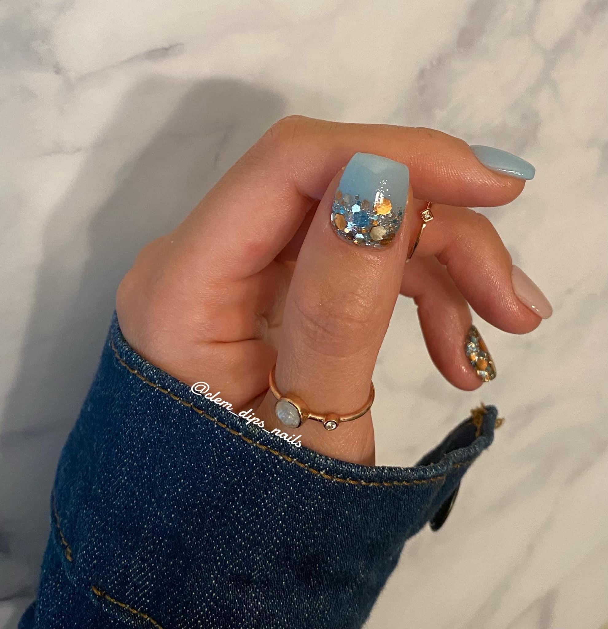 Blue nails with chunky copper and silver glitter accent on the ring finger.