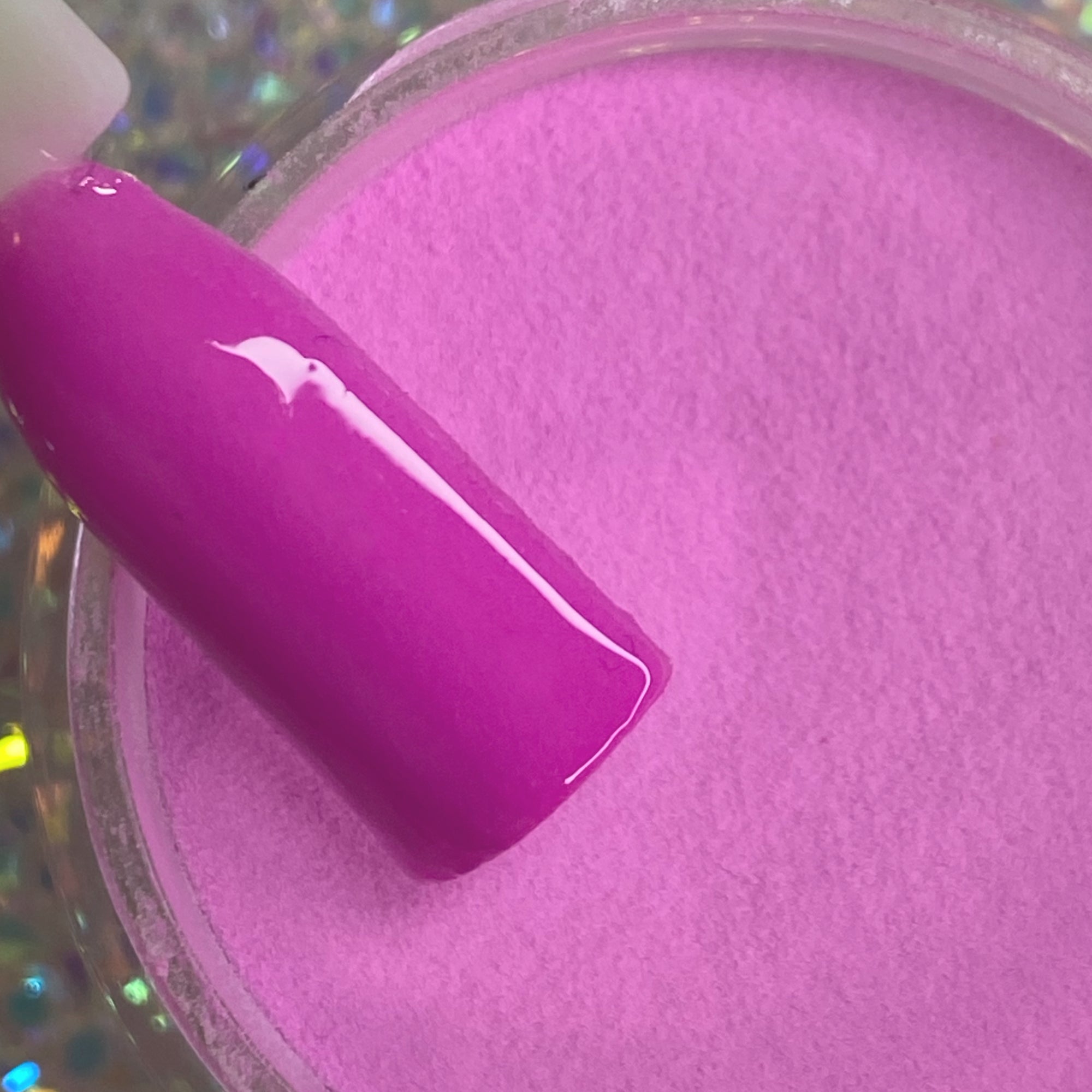 Glossy hot pink pastel dip powder with matching nail swatch on stick.