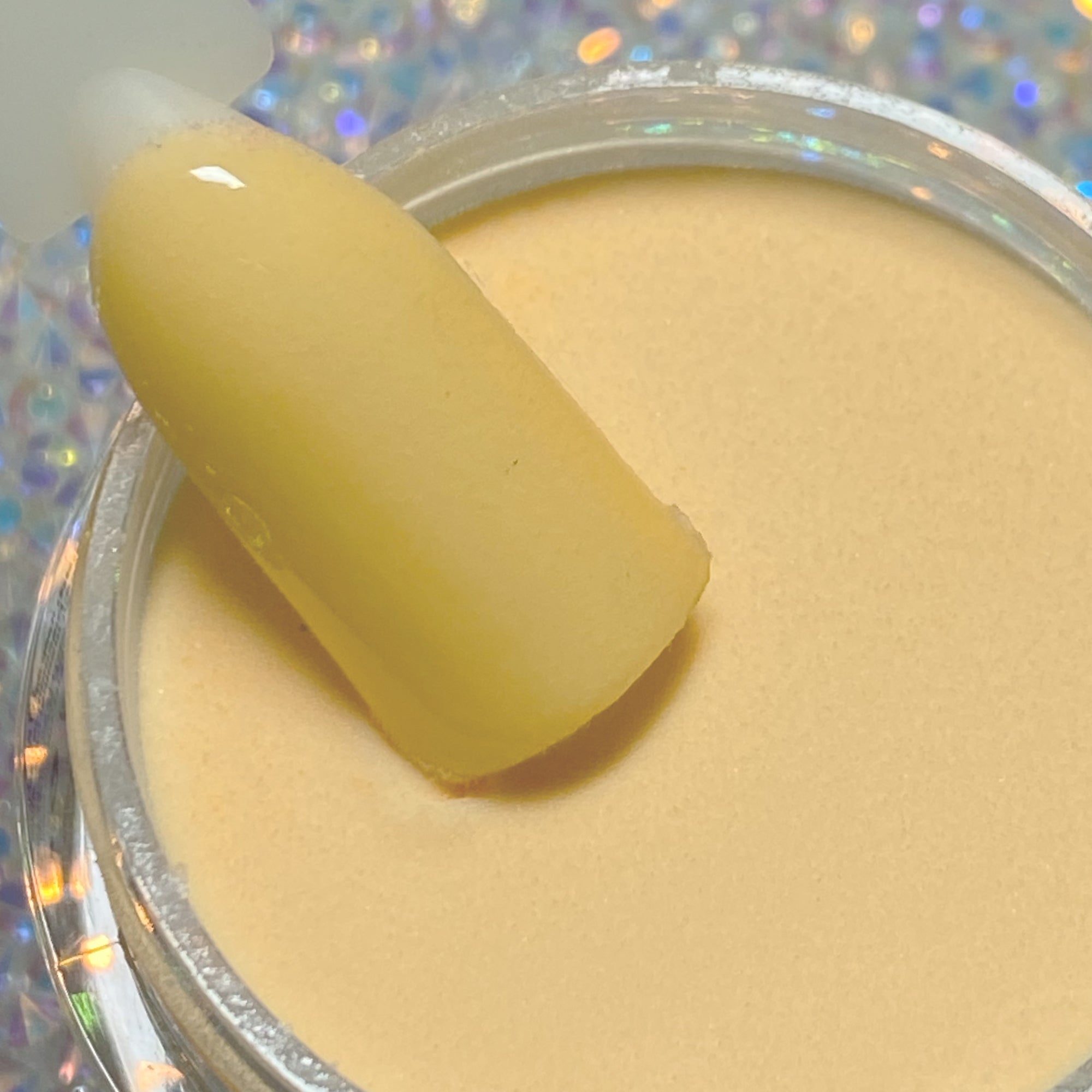 Light pastel yellow dip powder with smooth, creamy texture in a round container.
