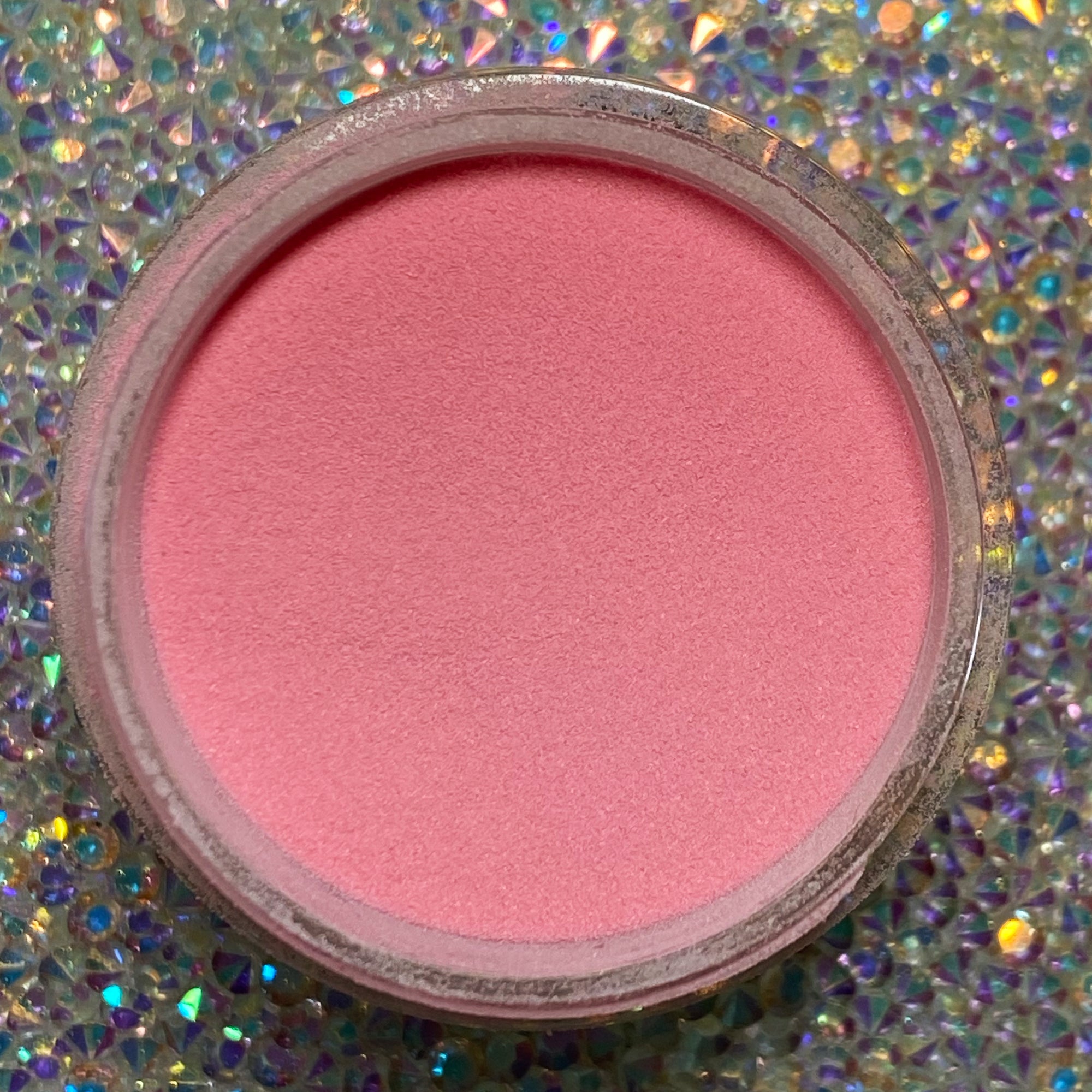 Open container of smooth pink dip powder nail color labeled DP142 Flamingo Floatie on holographic surface.