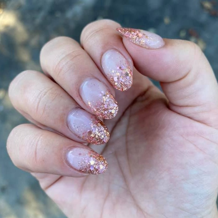 Pink and rose gold chunky glitter dip powder nails with almond shape on natural nails.