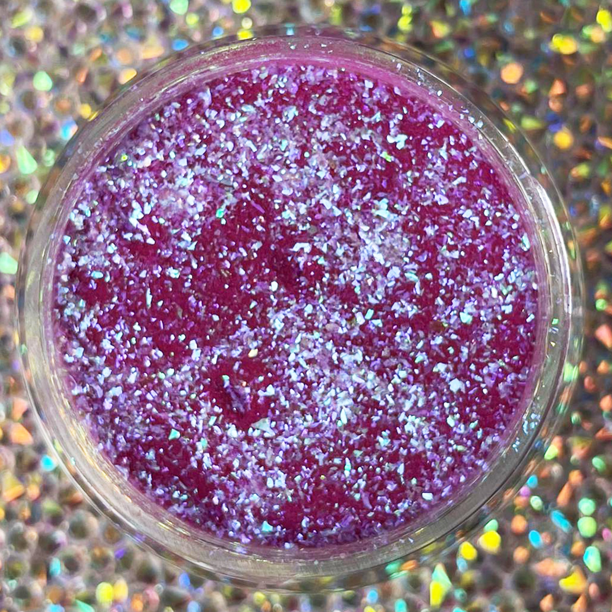 Small round container filled with vibrant purple glitter dip powder with multicolor chameleon flakes.