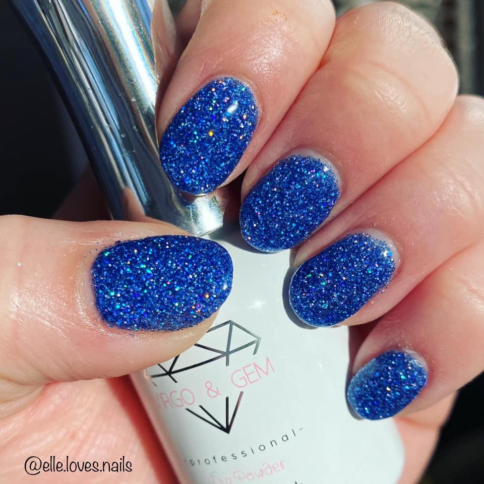 Bright blue holographic glitter dip powder nails with dense sparkling finish on short rounded nails.