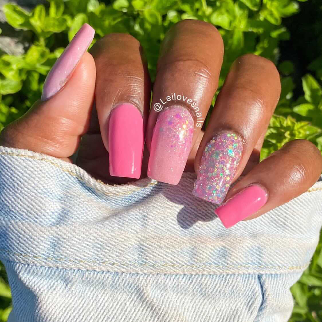 Glossy pink dip powder nails with two glitter accent nails on medium coffin-shaped tips.