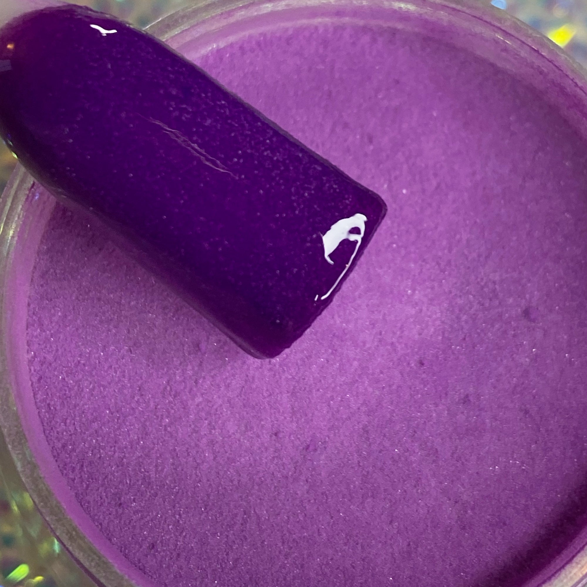 Vibrant purple dip powder with glossy nail swatch showing deep, rich color.