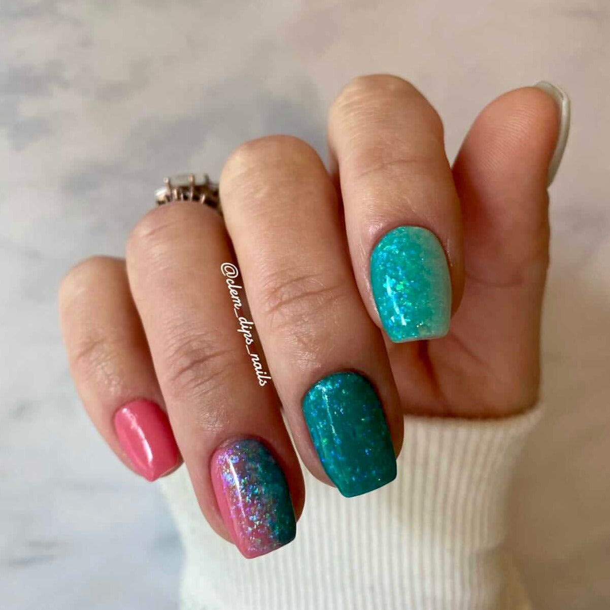 Teal and pink nails with multicolor chameleon flake shimmer on medium-length square tips.