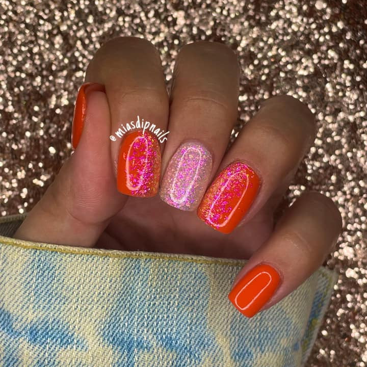 Orange and pink nails with chameleon flake glitter and glossy finish on short, square tips.