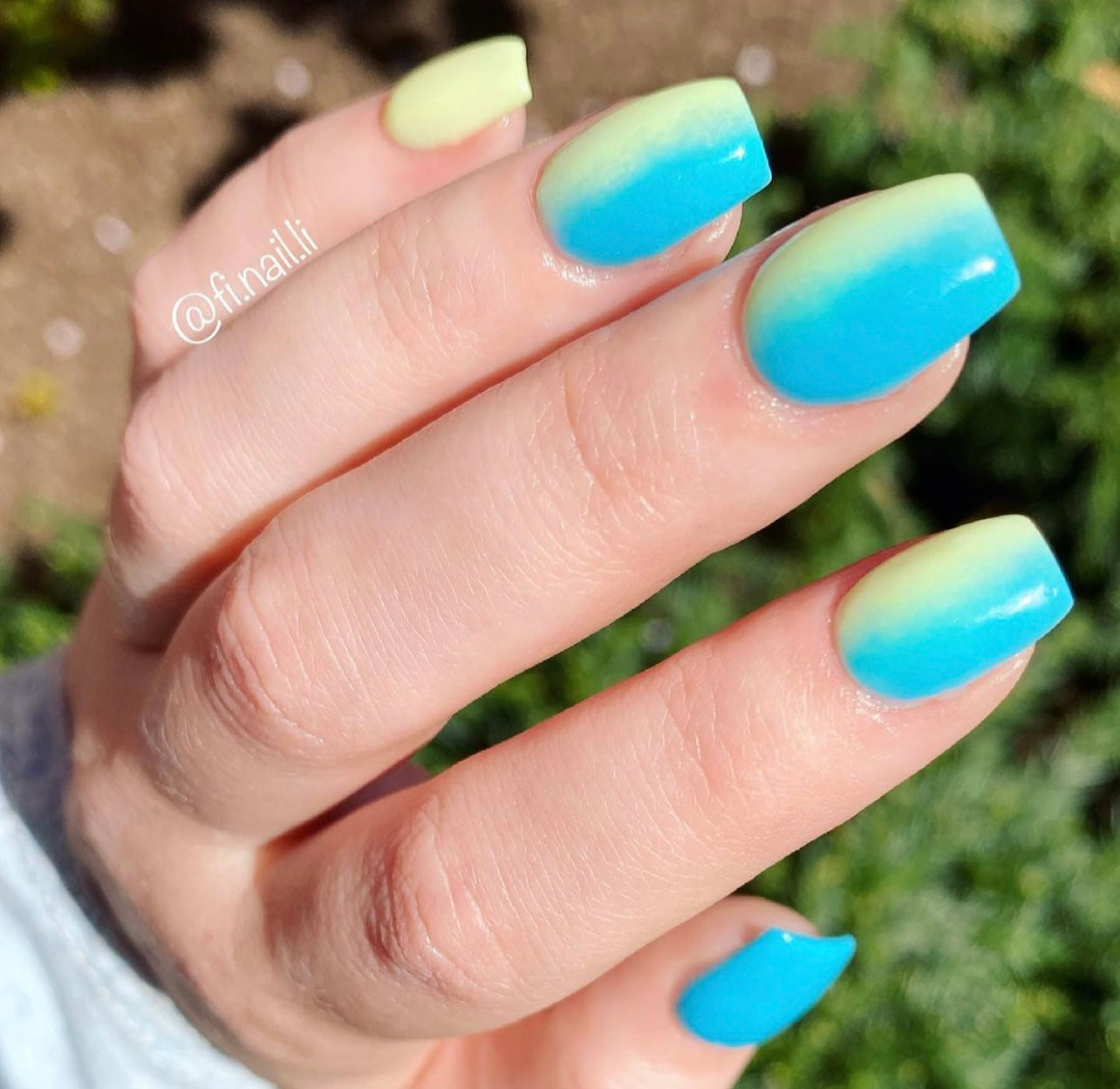 Nails with gradient dip powder polish transitioning from bright turquoise blue to lime green on a matte finish.