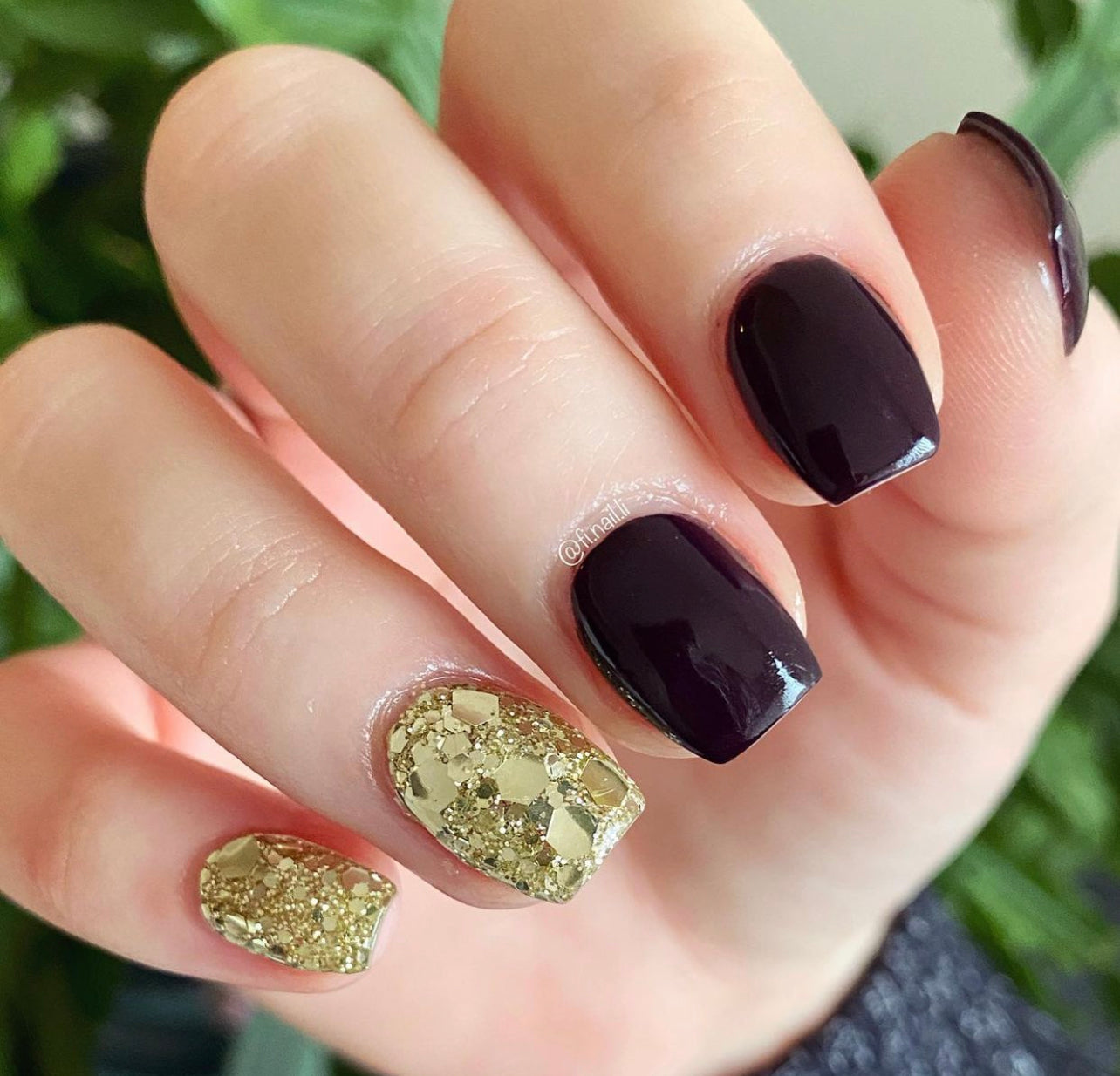 Manicure with deep purple nails and chunky silver glitter accent nails on ring and pinky fingers.