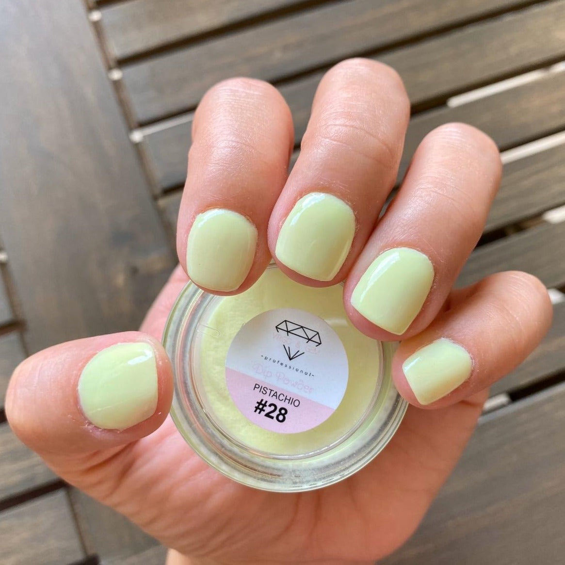 Pale pistachio green nail polish on short rounded nails with matching DP28 Pistachio dip powder jar.