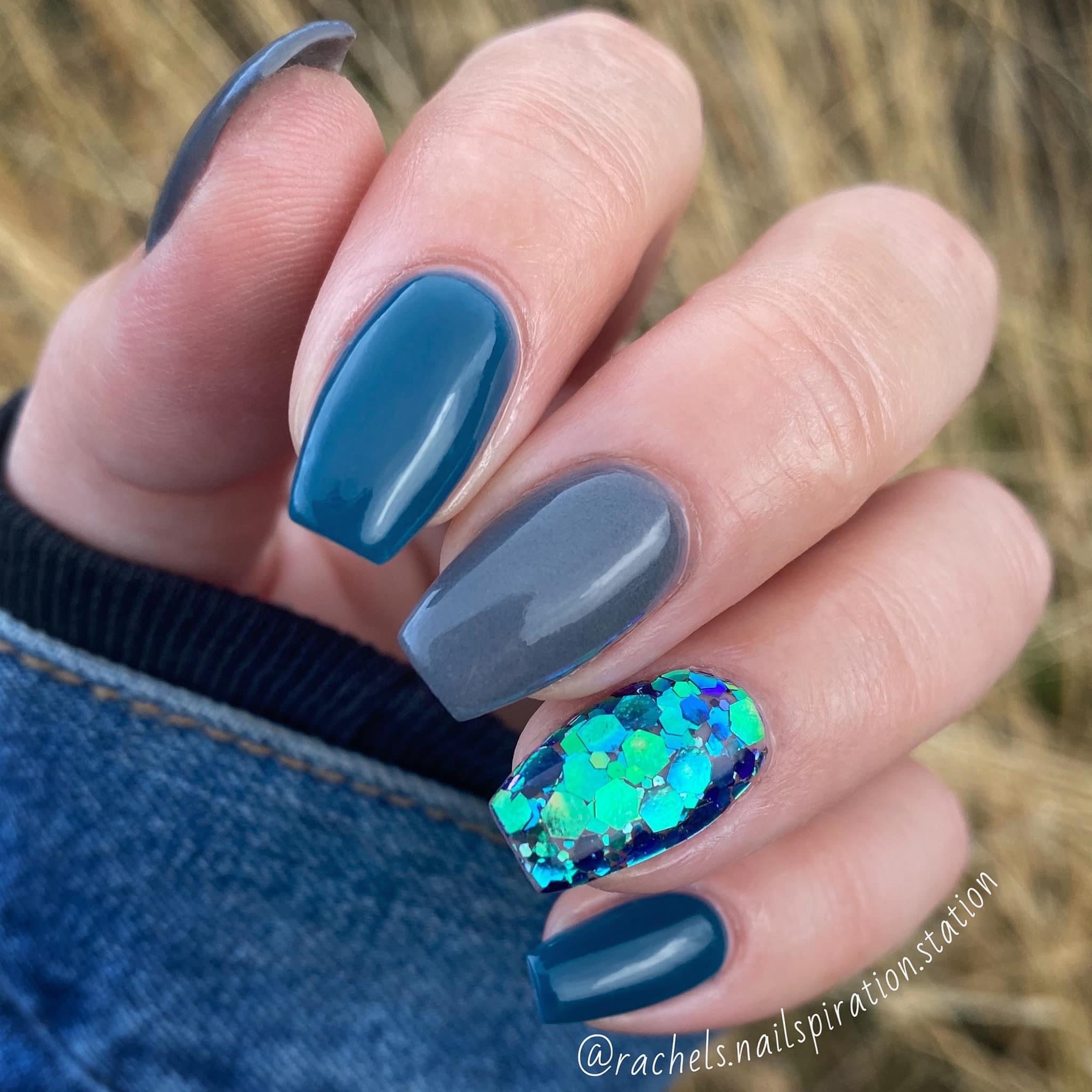 Blue and gray nails with chunky green and blue glitter accent nail on ring finger.