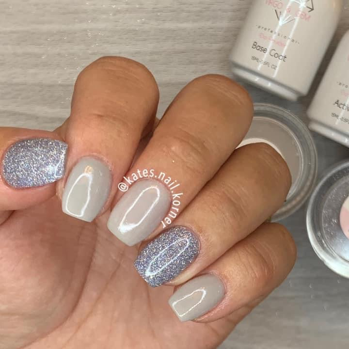 Short gray nails with glossy finish and glittery accent nails on ring and pinky fingers.