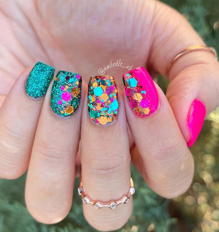 Nails with chunky multicolor glitter dip powder in teal, orange, pink, and berry tones on bright pink and teal bases.