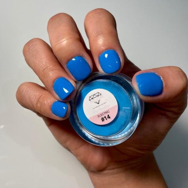 Hand with glossy neon blue nails holding container of DP14 Electric dip powder polish.