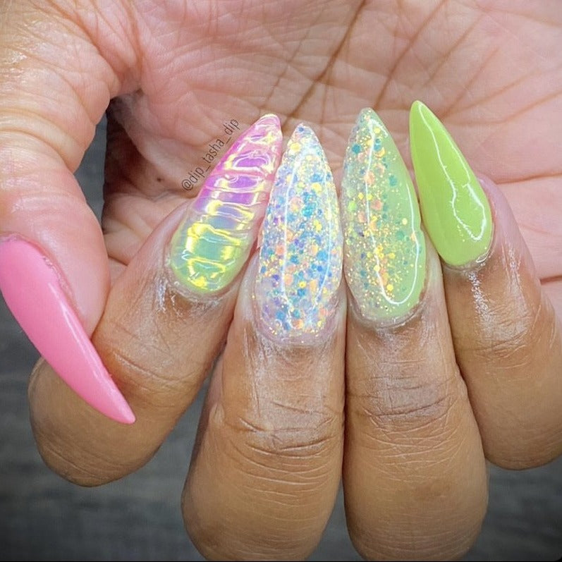 Long almond nails with pink, lime green, and iridescent chunky glitter dip powder designs on natural skin tone hand.