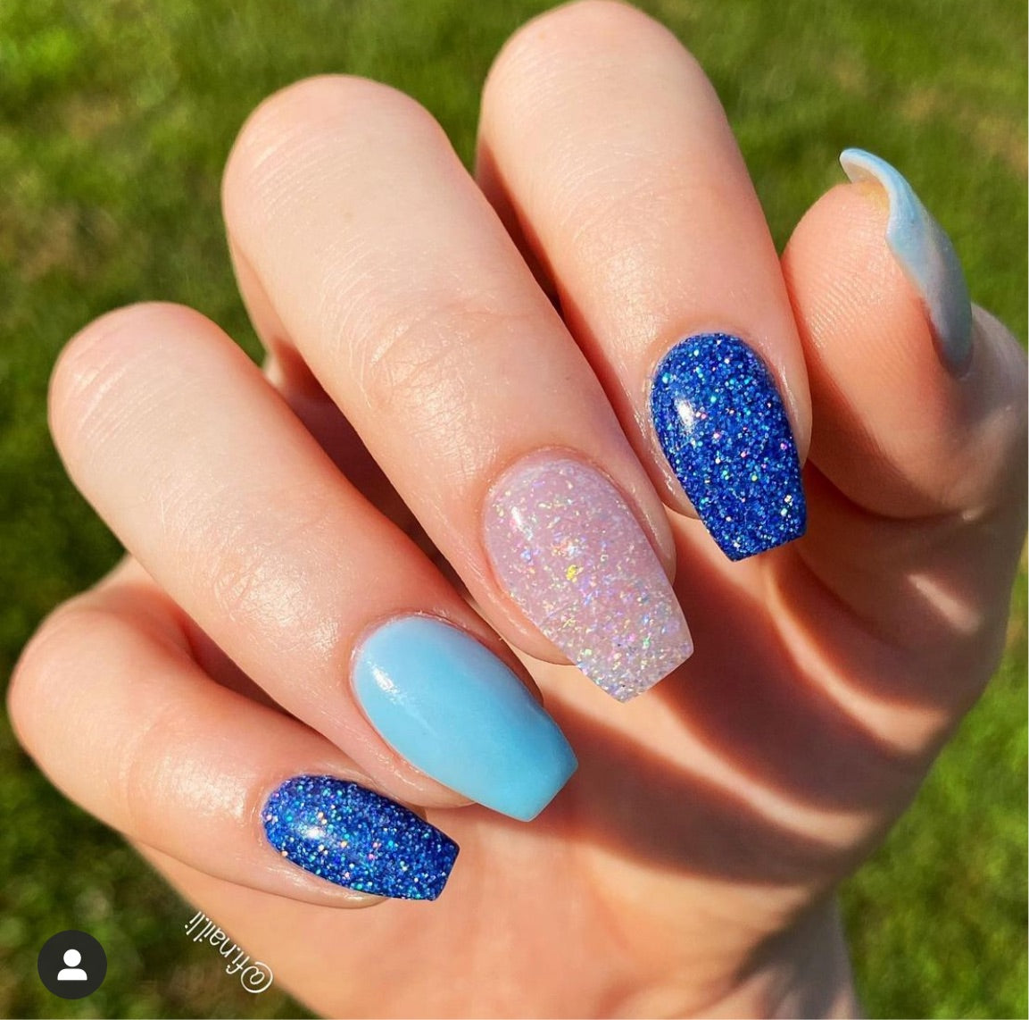 Holographic blue glitter and solid baby blue glossy nails with pink glitter accent nail.