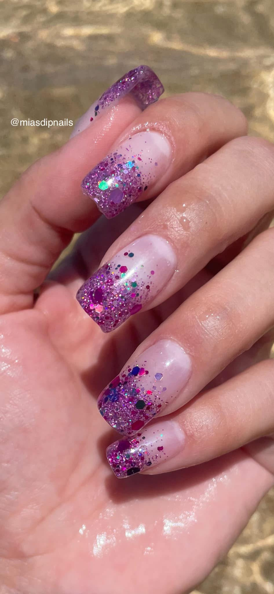 Long coffin nails with pink to purple ombre glitter and holographic chunky glitter accents.