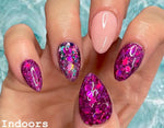 Glossy almond-shaped nails with pink and purple color-changing dip powder, featuring iridescent glitter and solid finishes.