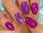 Purple and pink glossy nails with glitter and hexagonal sequins in various sizes.
