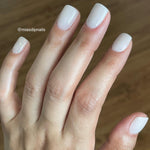 Glossy pale nude dip powder manicure on short square nails with subtle shimmer on ring finger.