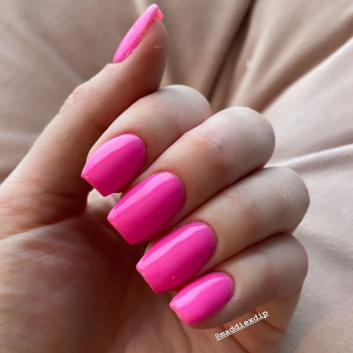 Bright hot pink polished nails with a smooth, glossy finish on medium square tips.