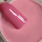 Glossy medium rose pink dip powder with smooth, solid finish in jar.
