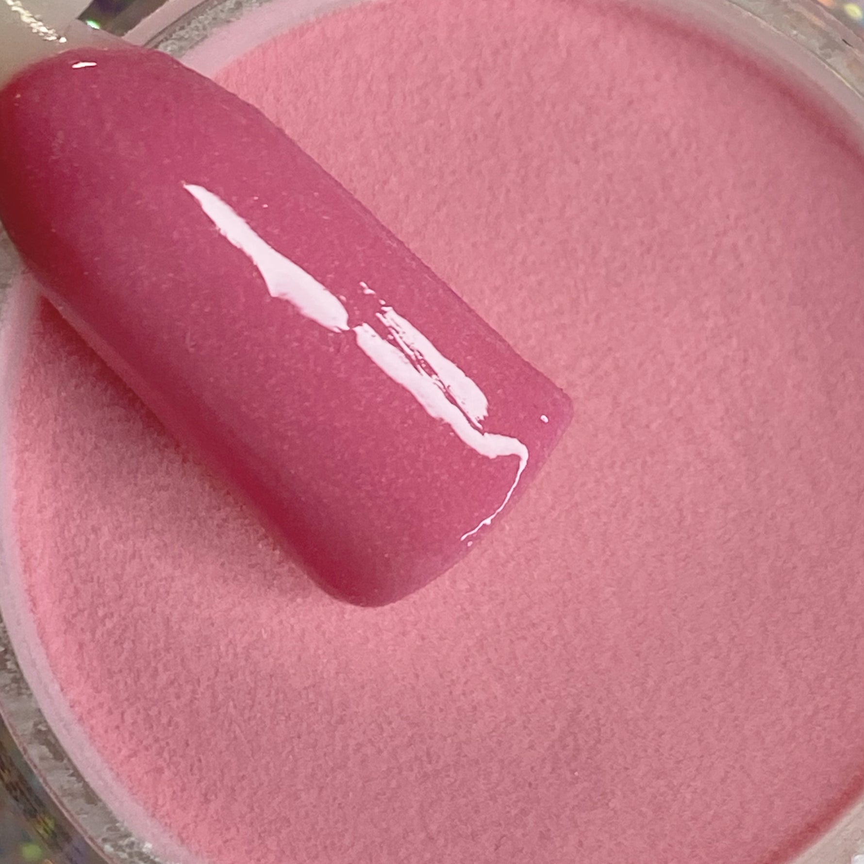 Glossy medium rose pink dip powder with smooth, solid finish in jar.