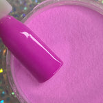 Glossy hot pink pastel dip powder with matching nail swatch on stick.