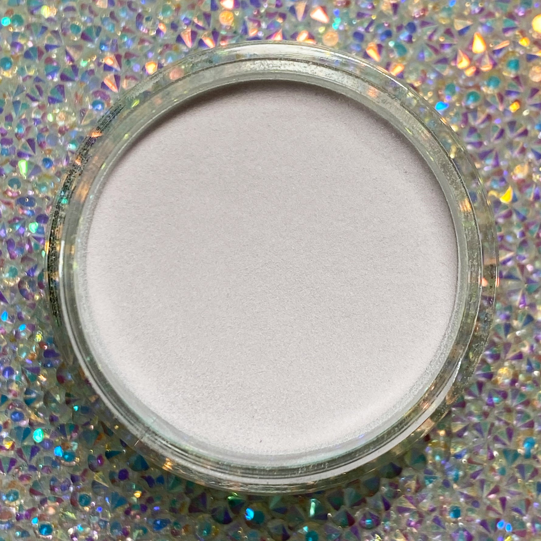 Open jar of smooth, pale beige dip powder nail polish with a subtle matte finish.