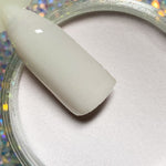 Smooth beige nude dip powder on a nail swatch stick above an open jar of powder.