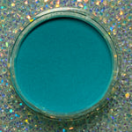 Open jar of vibrant teal dip powder on a sparkling holographic background.