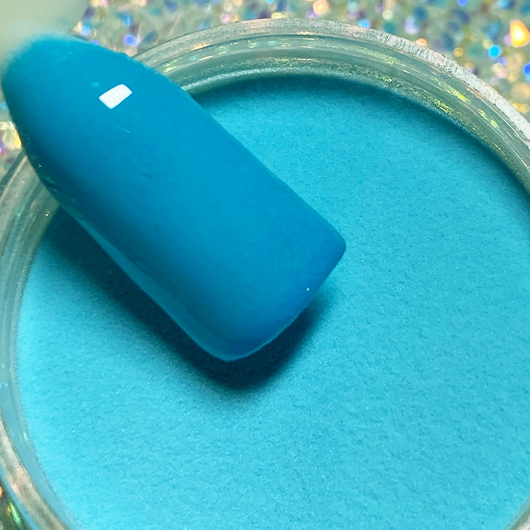 Bright turquoise blue solid dip powder with smooth matte finish on nail tip.