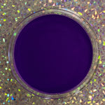 Deep purple solid dip powder in a clear round container against a holographic background.