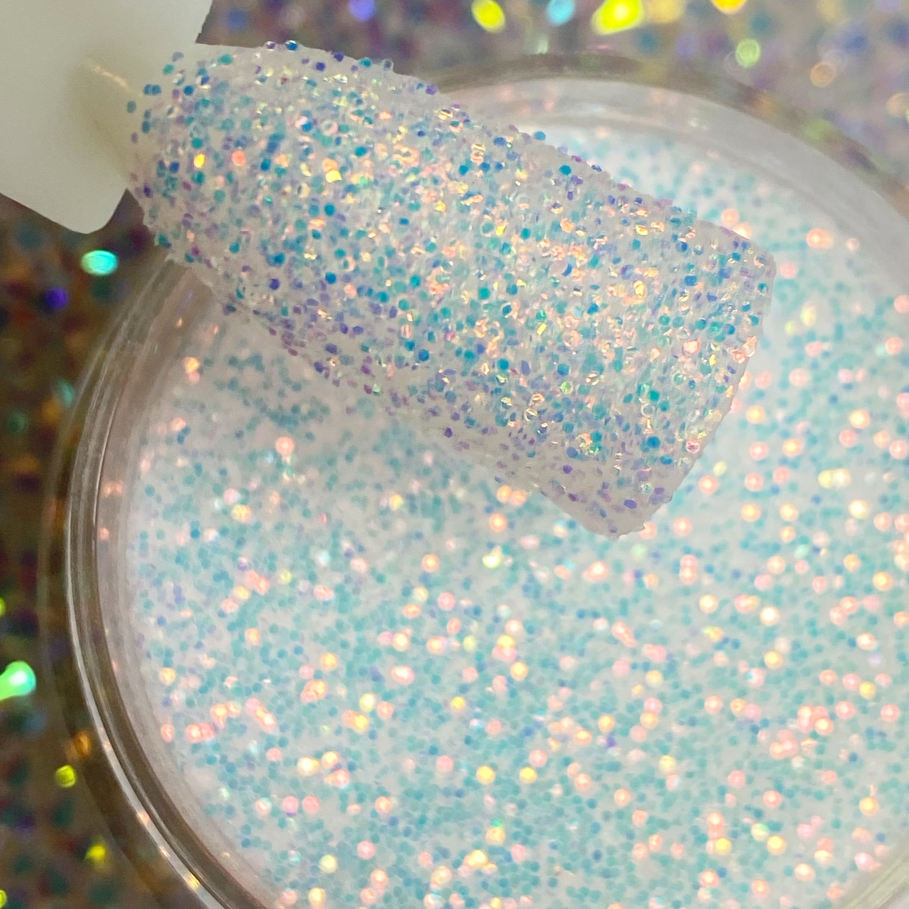 Fine iridescent white glitter dip powder with multicolor sparkles in a clear container.