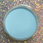 Open jar of fine, matte baby blue dip powder on holographic background.