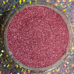 Fine rose gold glitter dip powder in round container on holographic background.