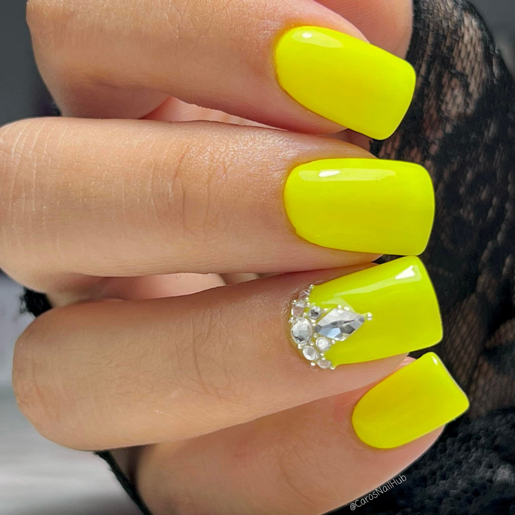 Bright neon yellow square acrylic nails with a rhinestone cluster accent on the ring finger.