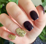 Manicure with deep purple nails and chunky silver glitter accent nails on ring and pinky fingers.