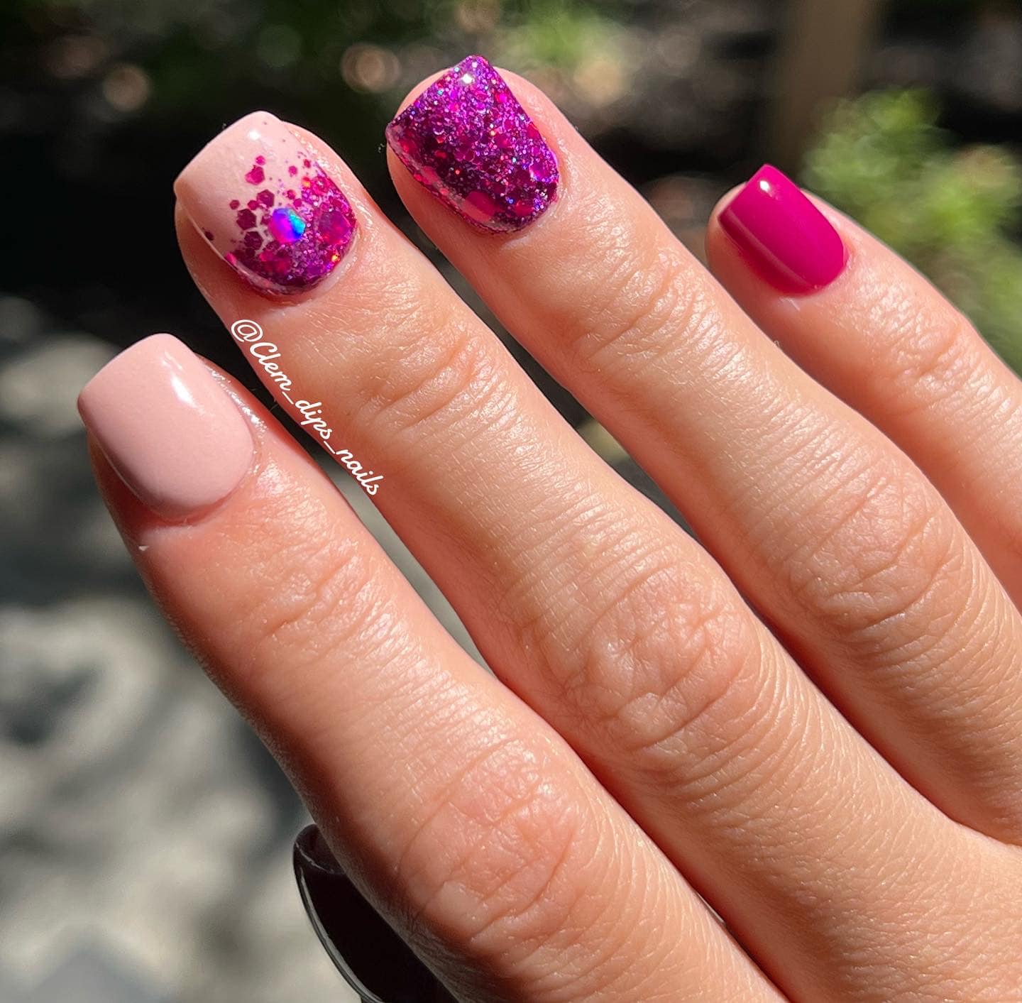 Manicure with soft nude pink, fuchsia with glitter, and solid deep pink dip powder nails.