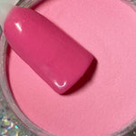 Bright pink solid dip powder with glossy nail swatch sample over open jar.