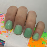 Mint green dip powder nails with fine shimmer and glitter on natural nails.