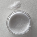 Clear jar filled with fine white glow-in-the-dark dip powder labeled DP V02 Full Moon with a small pile of loose powder.