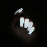 Long coffin-shaped nails glowing bright white in the dark with a smooth, solid finish.